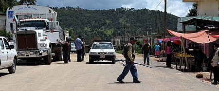 Polic&iacute;as comunitarios revisan veh&iacute;culos en Tlatlauquitepec rumbo a la carretera Tlapa-Chilpancingo luego del asesinato de cinco personas. Foto: Sergio Ferrer 