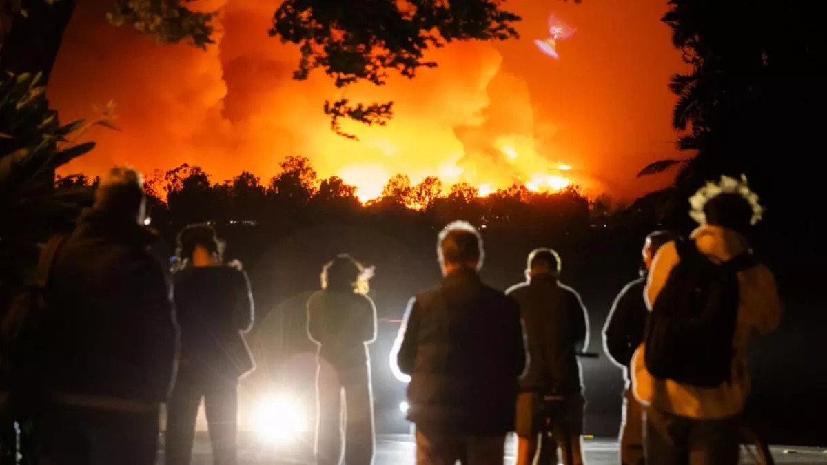 Un grupo de personas observa las llamas de Palisades, California. Foto: Tiffany Rose/Getty Images