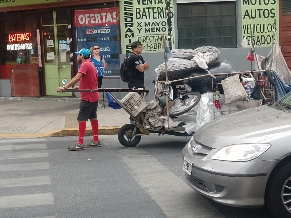 Un “cartonero“, como se llaman en Argentina a quienes recogen cosas de la basura urbana para reciclarlas o venderlas, mezclado entre el tránsito del barrio de Almagro, en Buenos Aires. Foto: Daniel Gutman / IPS