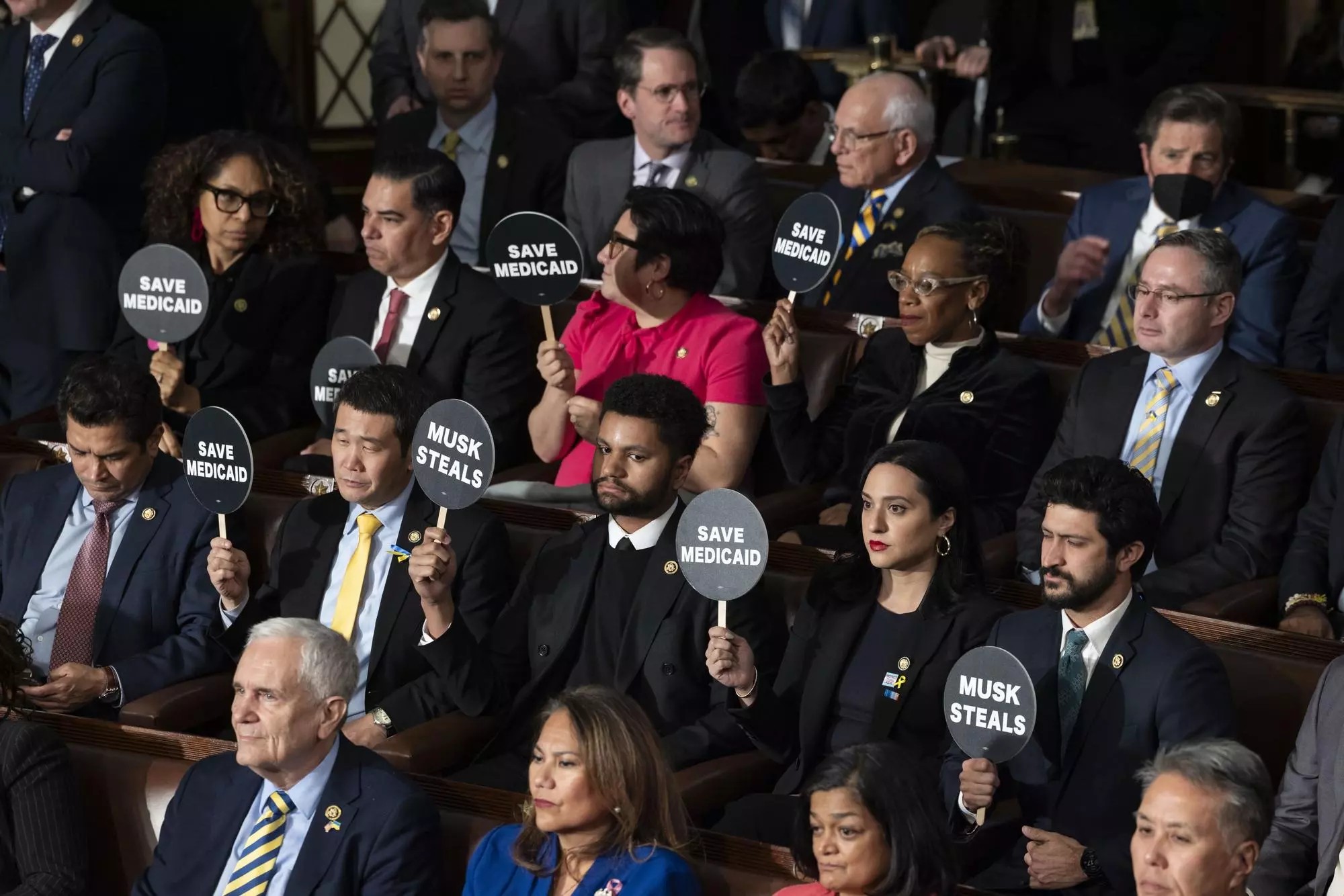 Los legisladores demócratas sostienen carteles durante el discurso de Trump. Foto: EFE/EPA/JIM LO SCALZO