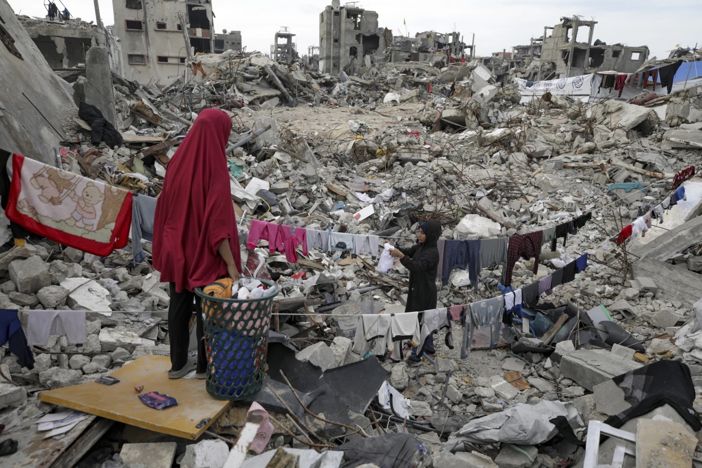 La familia Nijim tiende la colada entre las ruinas de su propiedad, en medio de una destrucción generalizada por la ofensiva aérea y terrestre de Israel en Jabaliya, Franja de Gaza, el 18 de febrero de 2025. (AP Foto/Jehad Alshrafi)