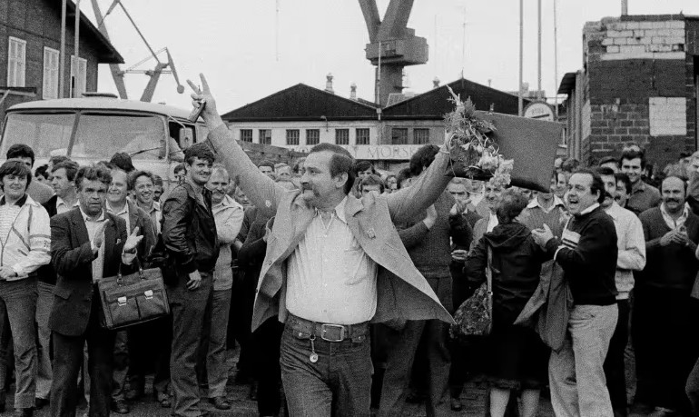 Wałęsa levanta los brazos ante una multitud que vitorea mientras sale del astillero en Gdansk, donde trabajaba, en junio de 1983. Foto: Jacques Langevin/AP.