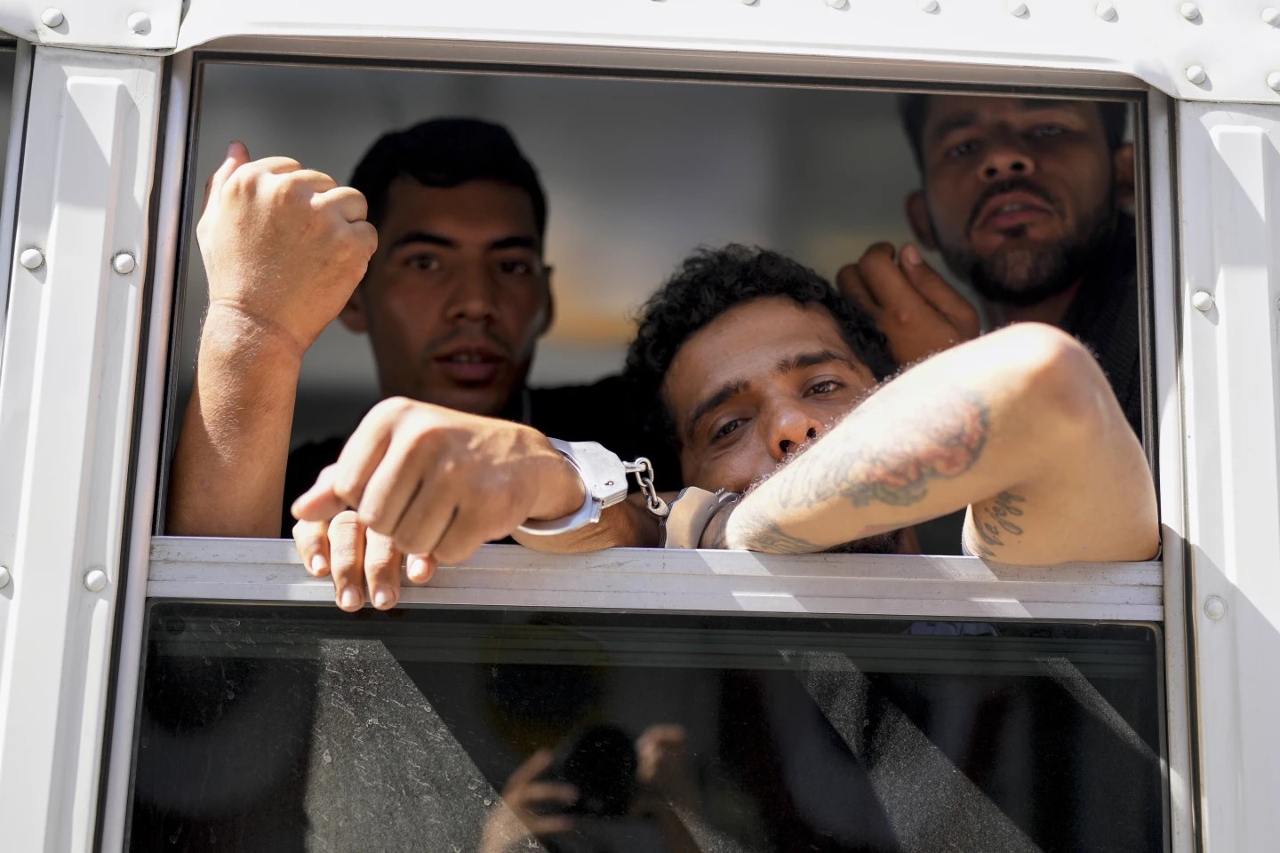 Cuatro colombianos muestran las marcas de las esposas en un viaje de deportación el 11 de marzo de 2025. Foto: AP/Matías Delacroix
