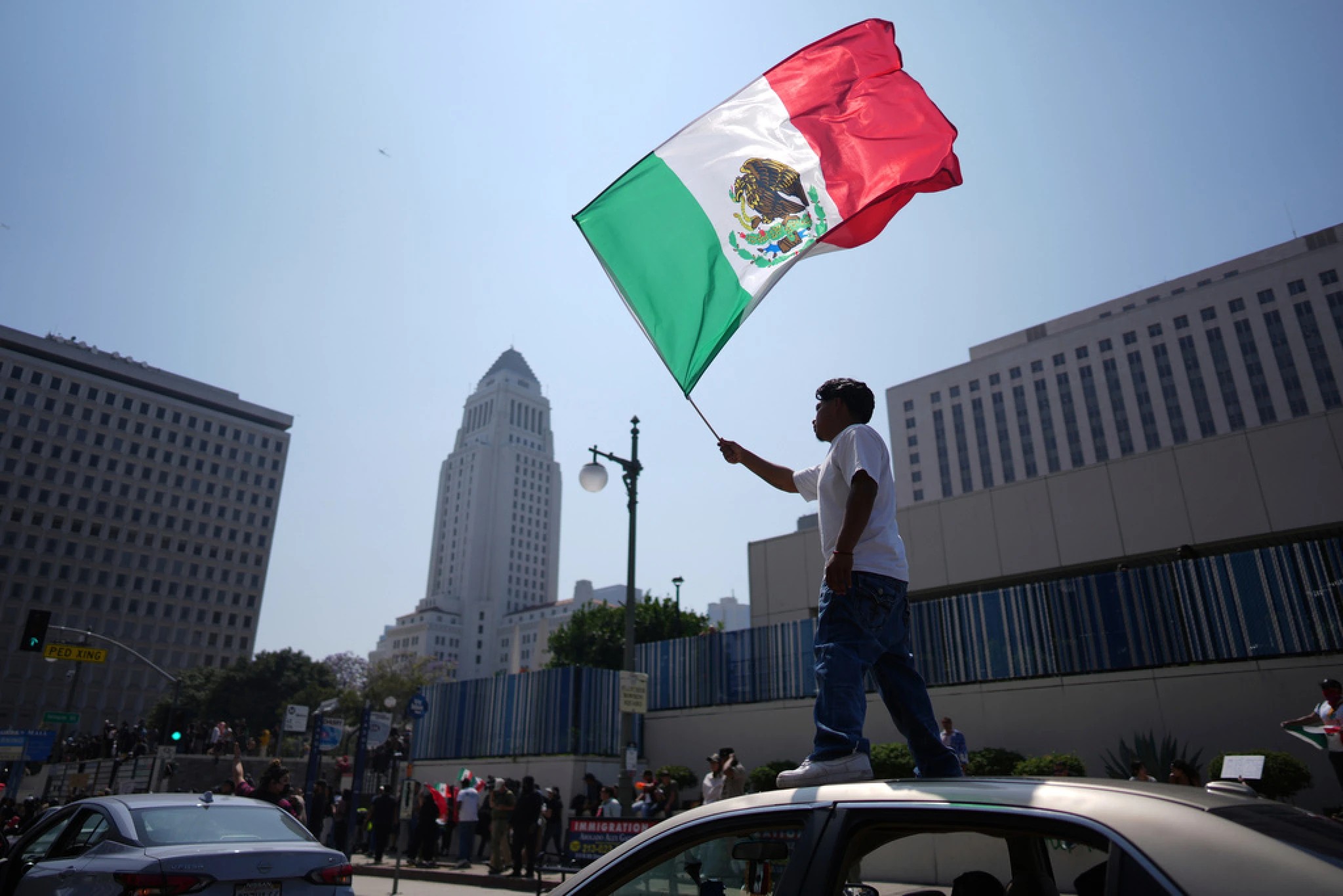 Un manifestante con la bandera mexicana cerca del centro de detención metropolitano en el centro de Los Ángeles. Foto: AP / Eric Thayer. Un manifestante con la bandera mexicana cerca del centro de detención metropolitano en el centro de Los Ángeles. Foto: AP / Eric Thayer.