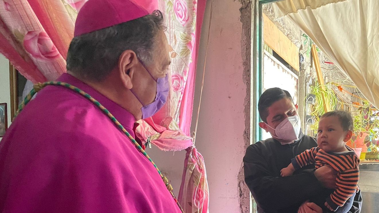 Bishop González Ramos (in a purple cassock) and Pallares Contreras (in a black cassock, holding a toddler) at a private home. March 2023. Social media of the diocese of Izcalli. Bishop González Ramos (in a purple cassock) and Pallares Contreras (in a black cassock, holding a toddler) at a private home. March 2023. Social media of the diocese of Izcalli.