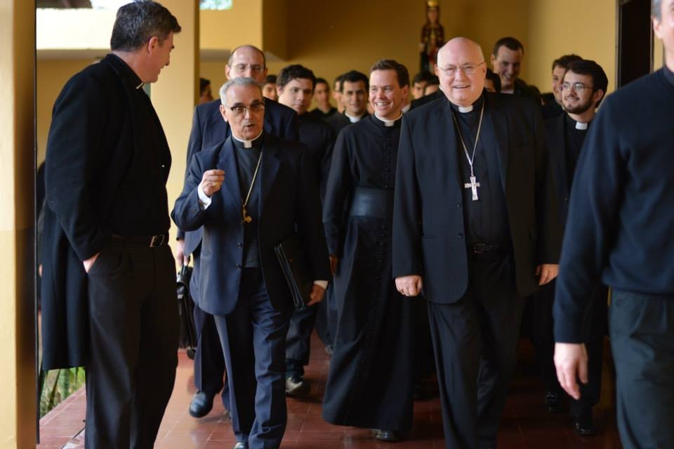 Con un portafolio, el cardenal español Santos Abril y Barceló durante el recibimiento al inicio de la visita apostólica a Ciudad del Este, Paraguay. A la derecha, el ahora finado obispo Rogelio Livieres Plano con una cruz pectoral, 2014. De una cuenta de redes sociales que usa el nombre de Livieres Plano @ www.facebook.com/photo/?fbid=1445332905735736&set=pb.100063689891826.-2207520000.