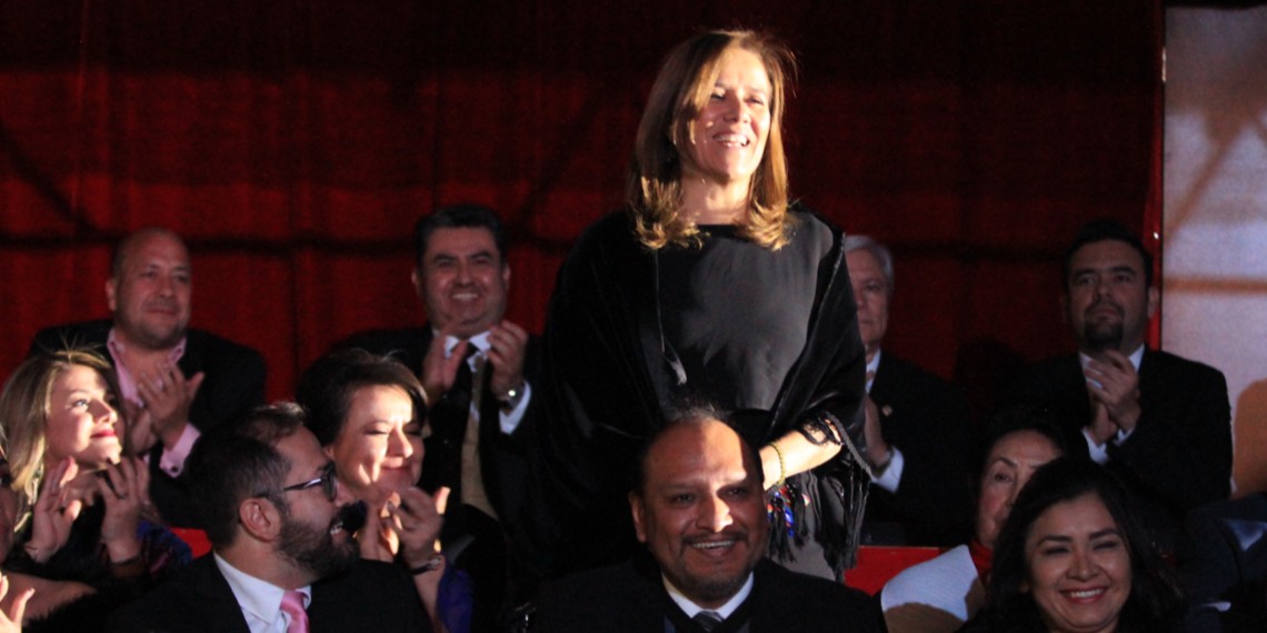De pie, la exprimera dama de México, Margarita Zavala, es aclamada por la multitud que celebra el aniversario de Naasón Joaquín García como líder de la Luz del Mundo. Detrás de ella, Enrique Alfaro y Naasón aplauden. 14 de diciembre de 2018. Redes sociales de Movimiento Ciudadano @ www.flickr.com/photos/dipciudadanos/45418829085/in/photostream/