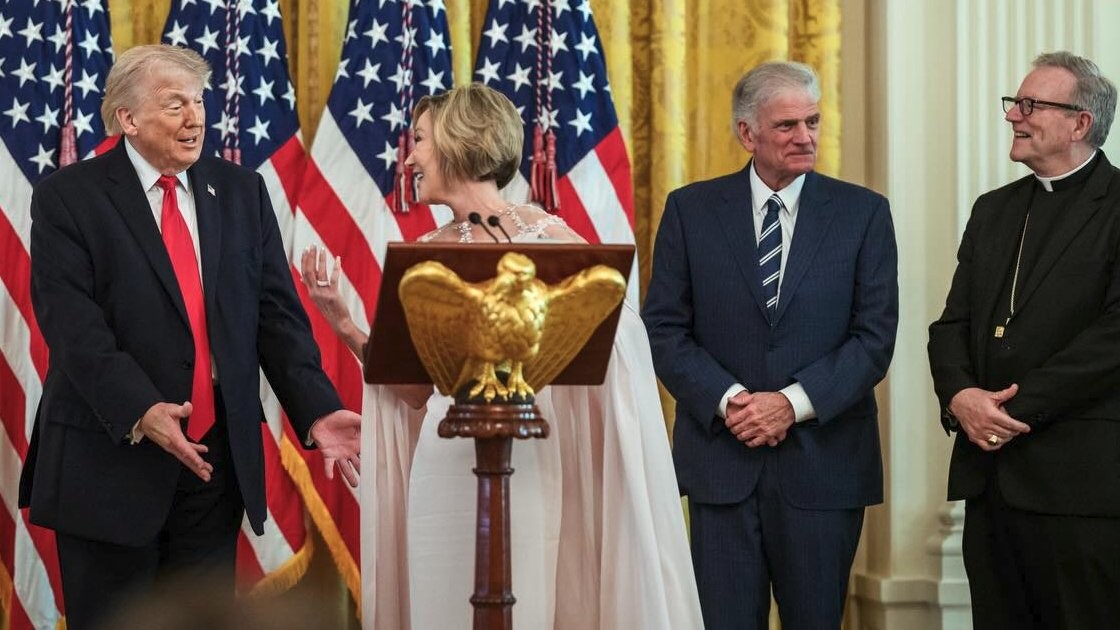 Paula White-Cain, a religious leader from Florida, addresses a gathering of her colleagues with Donald Trump on April 1, 2026. To White's left is Robert Jeffress of First Baptist Dallas, Texas, in a blue necktie, followed by Robert Barron, Catholic bishop of Winona-Rochester, Minnesota, in a Roman collar. White House Communication Office.