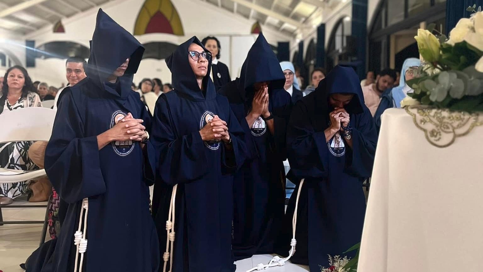 Four fully hooded friars kneeling in prayer before a statue of Mary the Virgin at the main chapel of the monastery compound in Berriózabal, Chiapas. Image published June 9, 2024, on FRICYDIM's social media. 