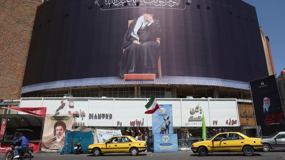 Un iraní sostiene la bandera nacional de Irán junto a una valla publicitaria con el difunto líder supremo iraní, el ayatolá Alí Jamenei, en la plaza Valiasr de Teherán, Irán, el 15 de junio de 2026. Foto: EFE/EPA/ABEDIN TAHERKENAREH Un iraní sostiene la bandera nacional de Irán junto a una valla publicitaria con el difunto líder supremo iraní, el ayatolá Alí Jamenei, en la plaza Valiasr de Teherán, Irán, el 15 de junio de 2026. Foto: EFE/EPA/ABEDIN TAHERKENAREH