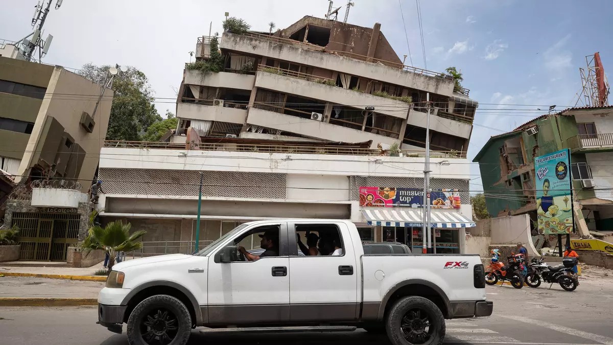 Un vehículo pasa frente a edificios afectados por los terremotos en La Guaira. Foto: Ronald Peña R. / EFE Un vehículo pasa frente a edificios afectados por los terremotos en La Guaira. Foto: Ronald Peña R. / EFE