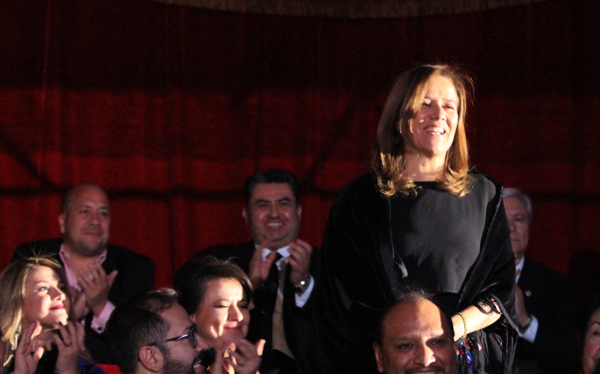 Standing, the former First Lady of Mexico, Margarita Zavala, is cheered by the crowd attending Naasón Joaquín García's celebration as leader of the Luz del Mundo Church. Behind her, Enrique Alfaro and Naasón are seen clapping. December 14, 2018. Movimiento Ciudadano Jalisco official feed at www.flickr.com/photos/dipciudadanos/45418829085/in/photostream/. Standing, the former First Lady of Mexico, Margarita Zavala, is cheered by the crowd attending Naasón Joaquín García's celebration as leader of the Luz del Mundo Church. Behind her, Enrique Alfaro and Naasón are seen clapping. December 14, 2018. Movimiento Ciudadano Jalisco official feed at www.flickr.com/photos/dipciudadanos/45418829085/in/photostream/.