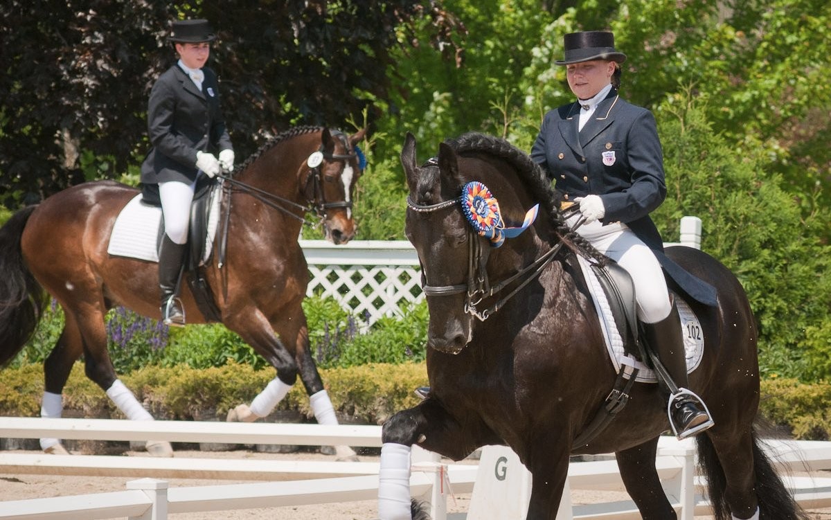 Dos atletas juveniles ecuestres durante una competencia de dressage, 2010. Imagen de Bob Haarmans en Flickr.